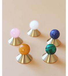 four different colored knobs on top of each other in various shapes and sizes,