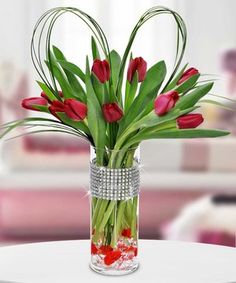 a vase filled with red flowers on top of a table