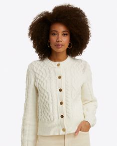 a woman wearing a white cable knit cardigan sweater