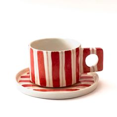 a red and white striped cup on a saucer