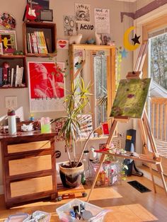 an artist's easel in front of a window filled with art supplies