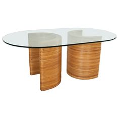 an oval glass and wood table with two circular wooden tables in the middle, one on each side