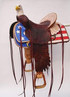 an eagle on top of a saddle with the american flag painted on it's back