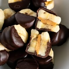 chocolate covered bananas are in a white bowl