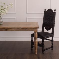 a wooden table with a vase on top of it next to a chair that has been turned into a bench