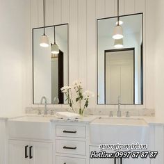 a bathroom with two sinks and three mirrors