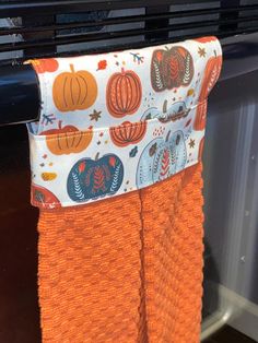 an orange towel is hanging on the oven rack