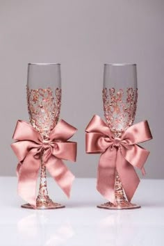 two wine glasses with pink bows on them