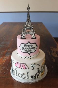 a three tiered cake with the eiffel tower on it's top