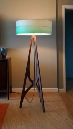 a lamp that is sitting on top of a wooden stand in a living room next to a door