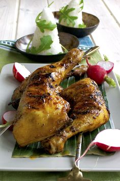 two pieces of chicken on a plate with radishes