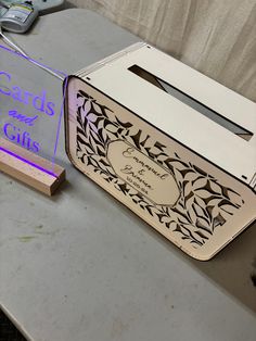 a cardboard box sitting on top of a table next to a sign that says cards and gifts