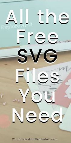 a laptop computer sitting on top of a wooden table next to paper and scissors with the words, all the free svg files you need