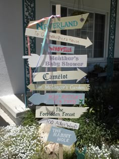 a sign that is in front of a house with many different signs on the post