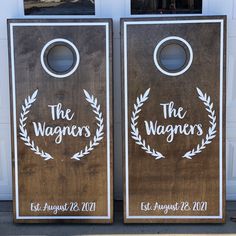 two wooden door hangers with the words the wagers and laurel wreaths on them