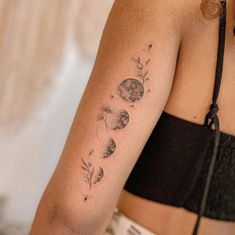 a woman with a tattoo on her arm that has flowers and leaves all over it