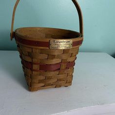 a wooden basket sitting on top of a white table next to a blue painted wall