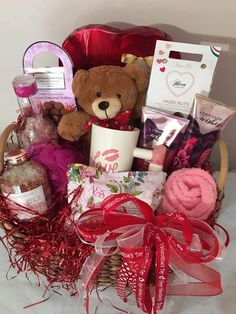 a teddy bear sitting in a basket filled with lots of goodies and other items