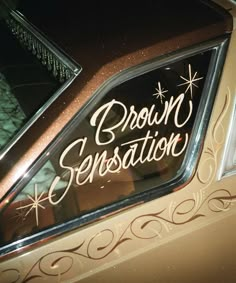 the back window of a brown car with writing on it that says, crown sensation