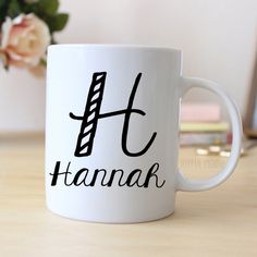 a white coffee mug with the word hanmak written in black ink on it