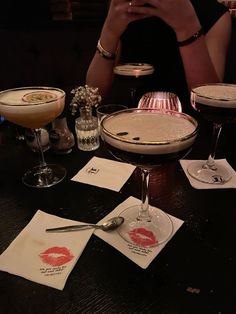 a table topped with glasses filled with different types of drinks