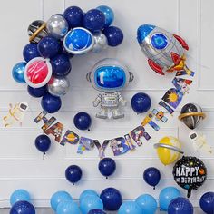 a space themed birthday party with balloons and streamers on the wall, including an astronaut balloon decoration