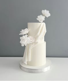 a white wedding cake with flowers on top