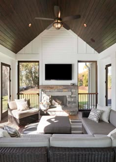 a living room with couches and a flat screen tv mounted on the wall above it