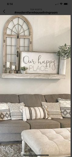 a living room with a couch, ottoman and sign on the wall that says our happy place