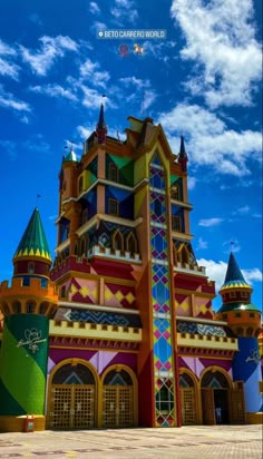 the colorful building has many windows on it's sides and is next to a blue sky