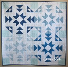 a blue and white quilt with triangles on it