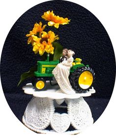 a bride and groom are riding on a tractor with yellow flowers in the back tire