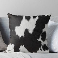 a black and white cow print pillow on a couch