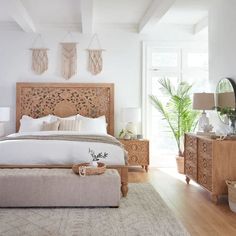 a bedroom with white walls and wooden furniture