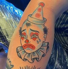 a man with a clown face tattoo on his arm