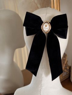 A beautiful Black velvet hair bow with an antique style rose cameo centre. A perfect hair bow for the festive season and would compliment your festive outfit wonderfully.  *DETAILS*  * The bow is attached to a silver french Barrett hair clip * measurements - 13cm across 19cm down * your bow will arrive in a gift box with luxury ribbon.  *DELIVERY DEATAILS* All UK orders are sent via the Royal Mail 1st Class Signed for service. All international orders are sent via a Tracked and Signed service wh Academia Hair, Dark Academia Hair, Cottagecore Hair, Clip Dark, Velvet Hair Bow, Diy Hair Accessories Ribbon, Gothic Hairstyles, Bow Barrette, Cottagecore Style