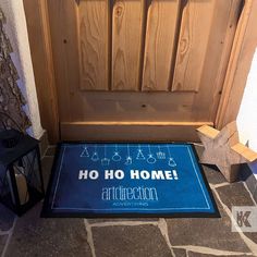 a blue door mat that says ho ho home on it next to a black lantern