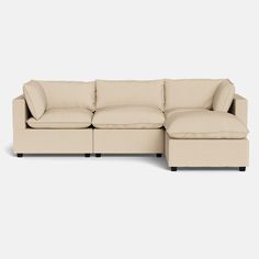 a beige sectional couch sitting on top of a white floor