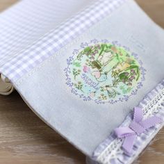 a close up of a book on a wooden table with a ribbon around the cover