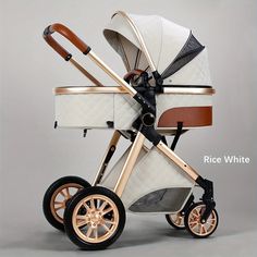 the baby stroller is white and gold with brown accents on it's wheels