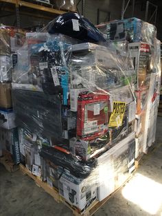 a large stack of magazines and other items on a pallet in a storage room