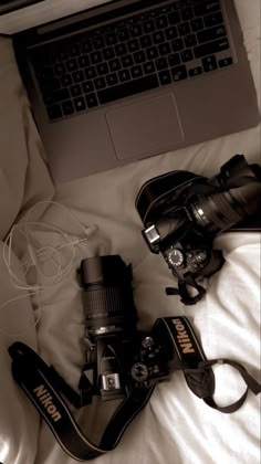 an open laptop computer sitting on top of a bed next to a pair of shoes