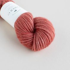 a skein of red yarn sitting on top of a white surface