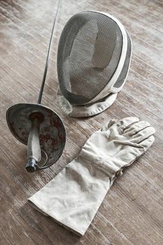 a pair of white gloves sitting on top of a wooden floor next to a frying pan