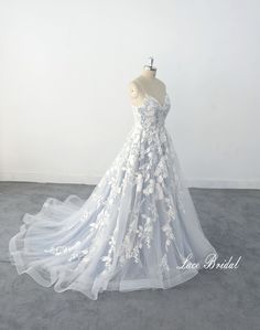 a white wedding dress on a mannequin in front of a white wall and floor