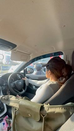 a woman sitting in the driver's seat of a car