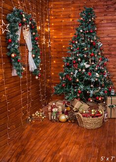 a christmas tree and presents in front of a wooden wall