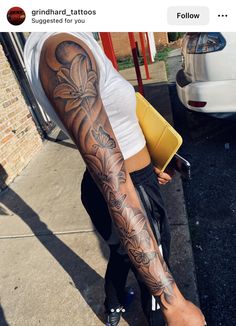 a woman with tattoos on her arm and leg is standing in front of a white car