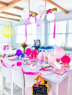 the table is set with pink and white decorations