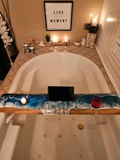 a bathtub with candles and a cell phone on it